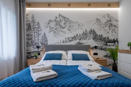 ein Schlafzimmer mit einem Bett mit einem Wandbild der Berge in der Unterkunft ZakoApartament Brzozowa in Zakopane