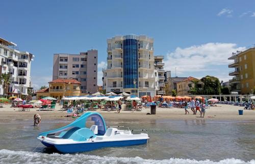 都拉斯Apartmán Hany的海滩上水中的蓝白船