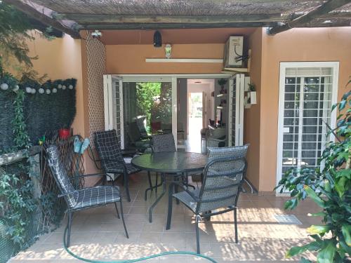 un patio con mesa y sillas en un porche en Islantilla - Bajo con Jardín en Golf Islantilla en Huelva