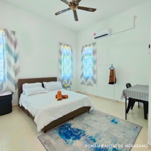 a bedroom with a bed with a teddy bear on it at Rumah Pantai de Merabang (bungalow with pool) in Bachok