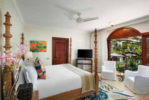 a bedroom with a large bed and a balcony at Cap Maison Resort & Spa in Cap Estate