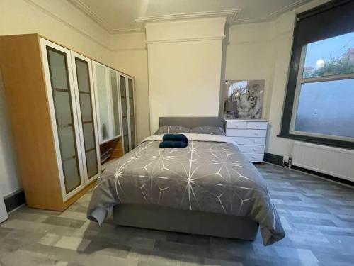 a bedroom with a bed and a large window at Ground Floor 2 Bed Flat with Garden North London in London