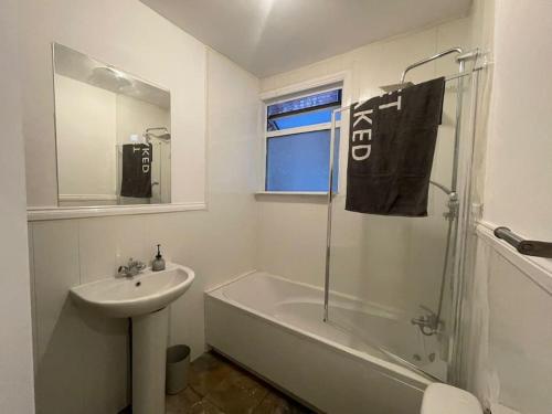 een badkamer met een wastafel, een douche en een bad bij Ground Floor 2 Bed Flat with Garden North London in Londen