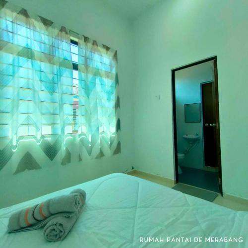 a bedroom with a bed with a towel on it at Rumah Pantai de Merabang (bungalow with pool) in Bachok