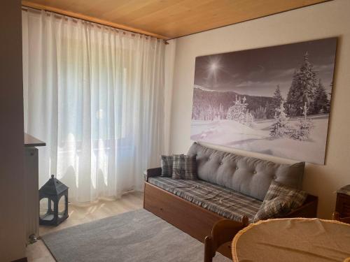 a living room with a couch and a large window at Casa Monte Zebio in Asiago