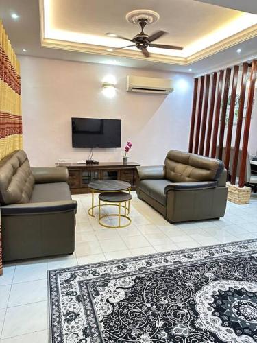 a living room with two couches and a flat screen tv at Rasa Sayang Homestay Shah Alam in Shah Alam