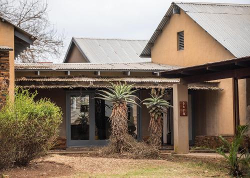 two palm trees in front of a house at Tala Collection Game Reserve in Silverton