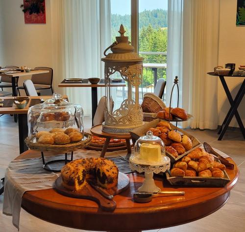 a tray of bread and pastries on a table at Boutique hôtel Corbetta - SPA 60m2 - La montagne à 5 minutes de l'autoroute A12 aux Paccots sur Montreux - NOUVEAU Loft familial - Profitez du Lac Léman et des montagnes en même temps in Les Paccots