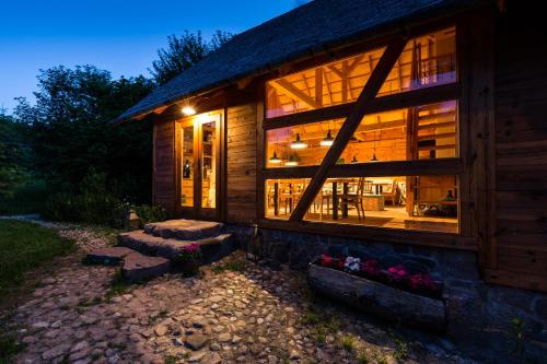 a log cabin with a large window at night at Cisowe Wzgórze in Rowele