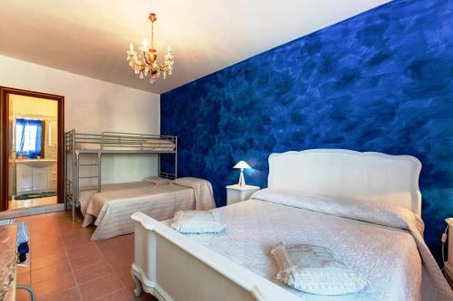 a bedroom with a blue accent wall and two beds at B&B Luna in Valmontone