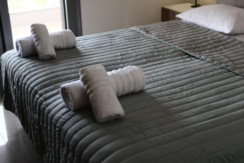 uma cama com toalhas enroladas em cima em Dream Maisonete With Garden Near In Sea em Kamárai