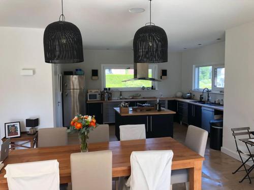 une cuisine et une salle à manger avec une table et des chaises en bois dans l'établissement Maison d'architecte sur le golf d'Hardelot, à Neufchâtel-Hardelot