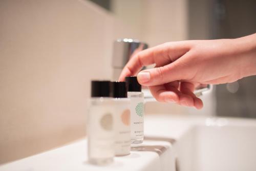 a hand is reaching for a bottle of moisturizing cosmetics at Thorpeness Golf Club and Hotel in Thorpeness
