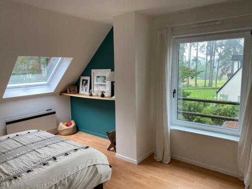 une chambre avec un lit et une grande fenêtre dans l'établissement Maison d'architecte sur le golf d'Hardelot, à Neufchâtel-Hardelot