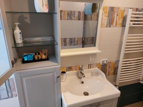 La salle de bains est pourvue d'un lavabo et d'un miroir. dans l'établissement Aglianico Guest House, à Naples