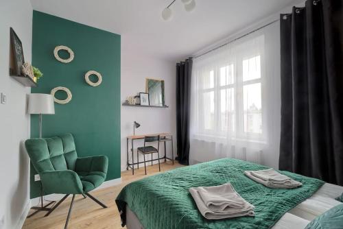 una camera con un letto e una sedia e una finestra di Urban Garden Hetmańska 3 a Poznań