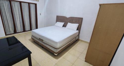 een slaapkamer met een bed en een bureau in een kamer bij Permata Homestay Kotamobagu Mitra RedDoorz in Poyowa-besar
