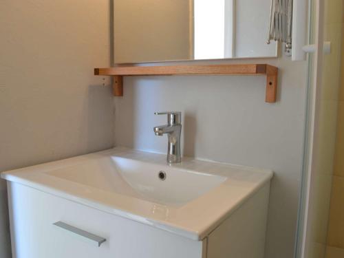 un lavabo blanc dans une salle de bain avec un miroir dans l'établissement Studio Cabine lumineux, loggia & plancha à Port Camargue, 4 couchages, ménage inclus - FR-1-250-161, au Grau-du-Roi