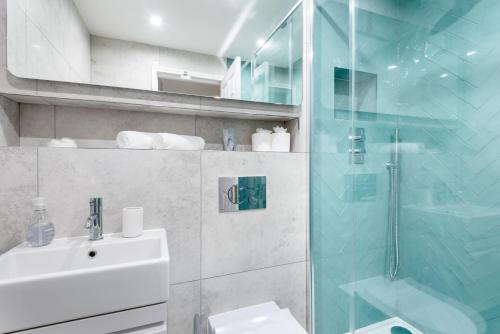 a bathroom with a sink and a glass shower at Hideaway - Exclusive marina development, town centre, with parking in Falmouth