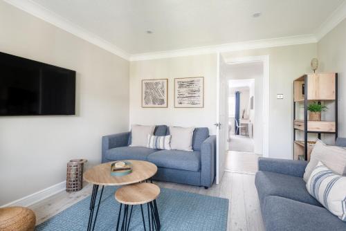 a living room with a blue couch and a table at Hideaway - Exclusive marina development, town centre, with parking in Falmouth