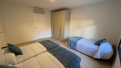 a bedroom with two beds with blue pillows at Txoko Loft Ribera in Tudela