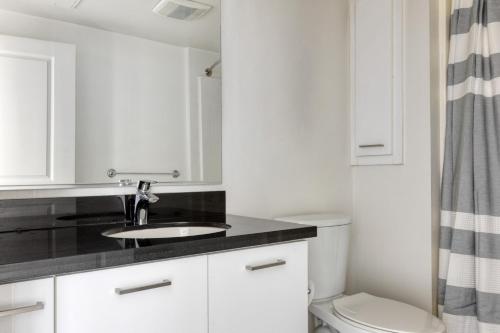 a white bathroom with a sink and a toilet at Downtown Studio w Pool Gym nr Broad Museum LAX-601 in Los Angeles
