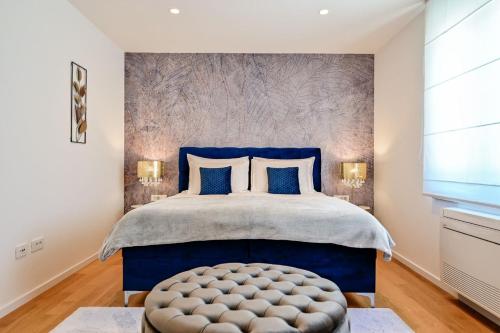 a bedroom with a bed with a blue headboard and a blue ottoman at Apartments Lena in Malinska