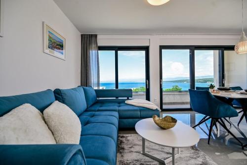 a living room with a blue couch and a table at Apartments Lena in Malinska