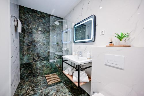 een badkamer met een wastafel en een douche bij Apartments Lena in Malinska