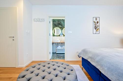 a bedroom with a bed and a bathroom with a sink at Apartments Lena in Malinska