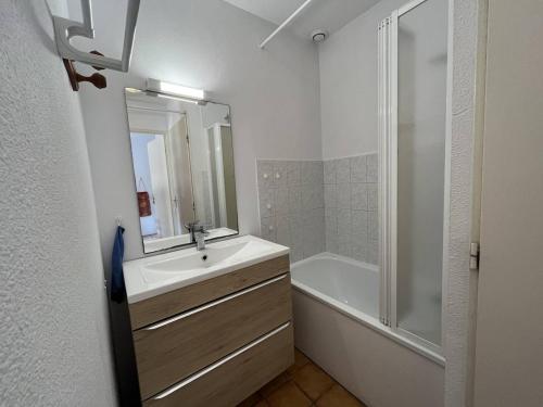 une salle de bain blanche avec un lavabo et une douche dans l'établissement Villa T2 Mezzanine 6 pers avec Jardin, Piscine, Proche Plage - Saint-Cyprien - FR-1-106-27, à Saint-Cyprien