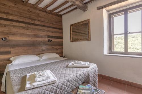 a bedroom with a bed and a window at Antica Porta di Sovana 2.0 in Pitigliano