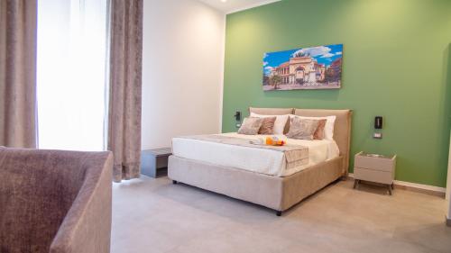 una camera con letto e parete verde di Palermo Historia a Palermo
