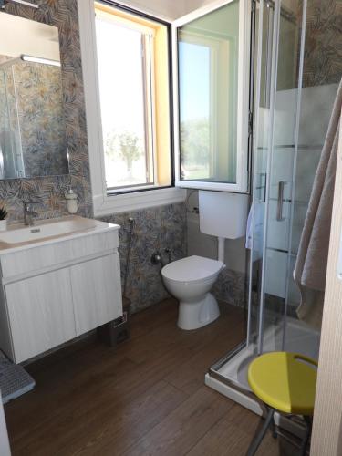 a bathroom with a toilet and a sink and a shower at Villa Corradina in Floridia