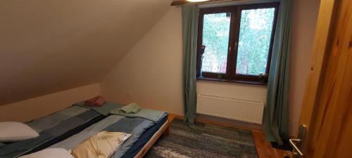 a small room with two beds and a window at Chataa in Szczechy Małe