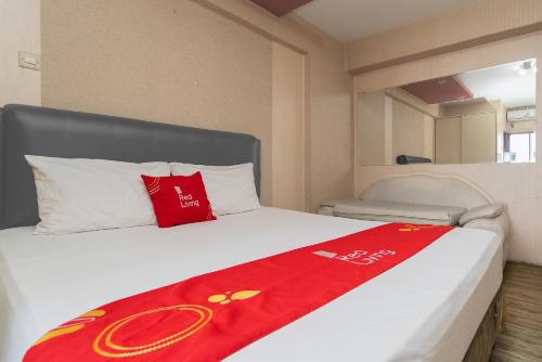 Una cama con una manta roja encima. en RedLiving Apartemen Gateway Cicadas - Premium Property, en Bandung