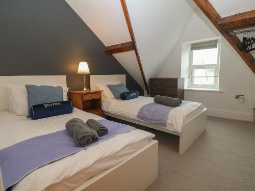 a attic bedroom with two beds and a window at Apartment 2, Gorwel Glas in Pwllheli