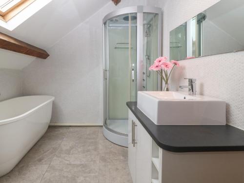 a white bathroom with a sink and a shower at Apartment 2, Gorwel Glas in Pwllheli