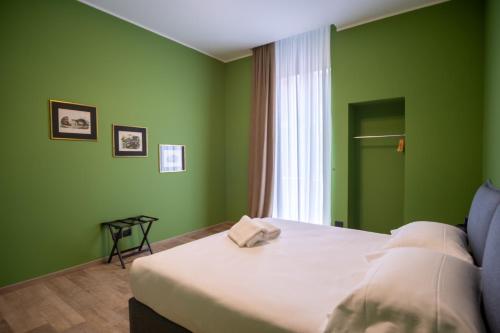 Dormitorio verde con cama y ventana en Palazzo Zippitelli Apartments en Bari