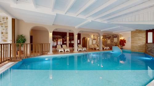 a large swimming pool in a house with a ceiling at Acrotel Athena Pallas in Elia