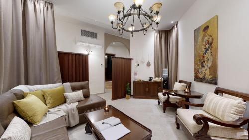 a living room with a couch and chairs and a chandelier at Acrotel Athena Pallas in Elia