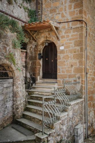 a black cat sitting in front of a door at Antica Porta di Sovana 2.0 in Pitigliano