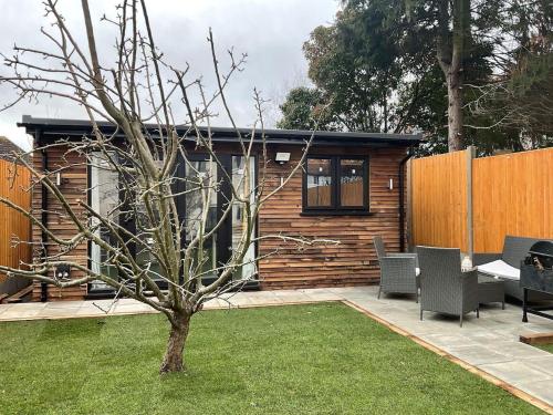 a small house with a tree in a yard at Studio - Sleeps 2 - Pet friendly - Parking in Hendon