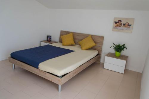 a bedroom with a bed with yellow and blue pillows at Attico lavanda in Silvi Paese