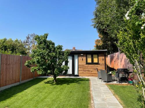 a small garden with a wooden fence and a house at Studio - Sleeps 2 - Pet friendly - Parking in Hendon