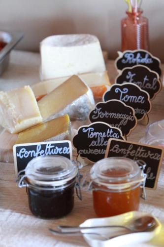 a table topped with different types of cheese and jam at Bed & Brekfast da Kate Dreams and Colors in Foglizzo