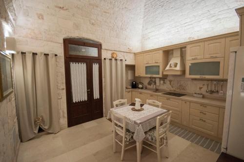 une cuisine avec une table et des chaises dans une pièce dans l'établissement Locorotondo Stone House, à Locorotondo