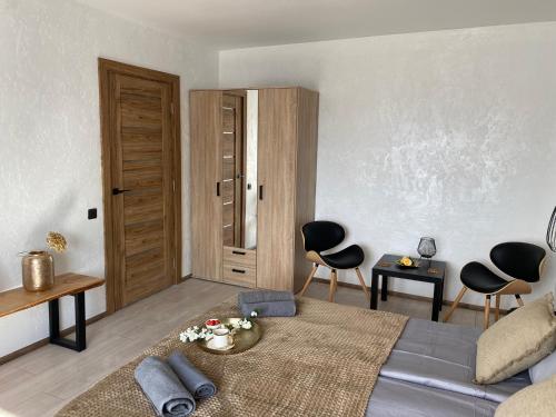 a bedroom with a bed and two chairs and a table at Apartamenti Ezera Pērle in Alūksne