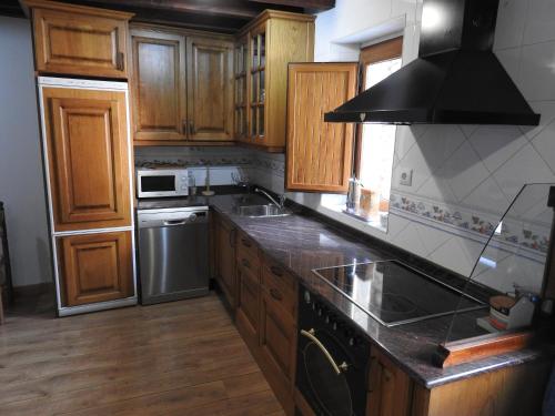a kitchen with wooden cabinets and a stove top oven at CASUCA LA SOLANA in Potes