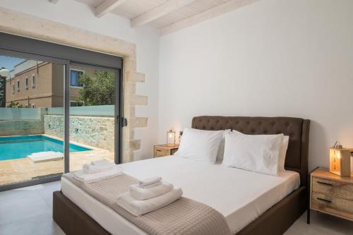 a bedroom with a bed and a pool at Megalith Villas in Nea Kydonia